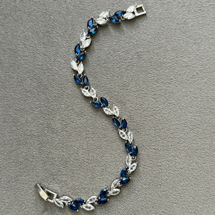 Silver tennis bracelet with blue and clear marquise stones, open box clasp, full view