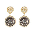 Gold-tone moon and star dangle earrings with dark round enamel and crystal accents