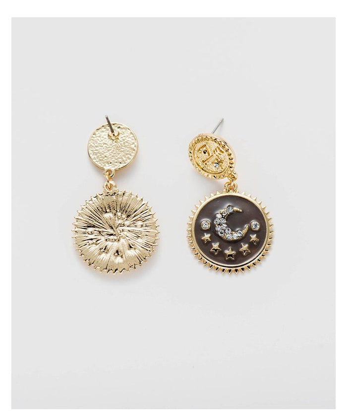 Gold-tone moon and star dangle earrings with textured drop and dark circular enamel