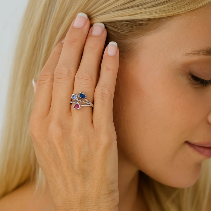 Silver-tone cubic zirconia ring with blue oval stone and red/pink drop accent