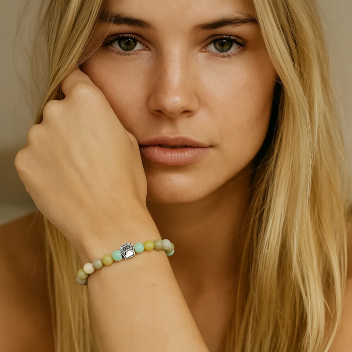 Beaded paw charm bracelet on model’s wrist with pastel beads and silver charm