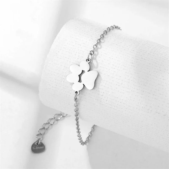 Silver link chain paw cutout charm bracelet with large paw charm and small disc charm