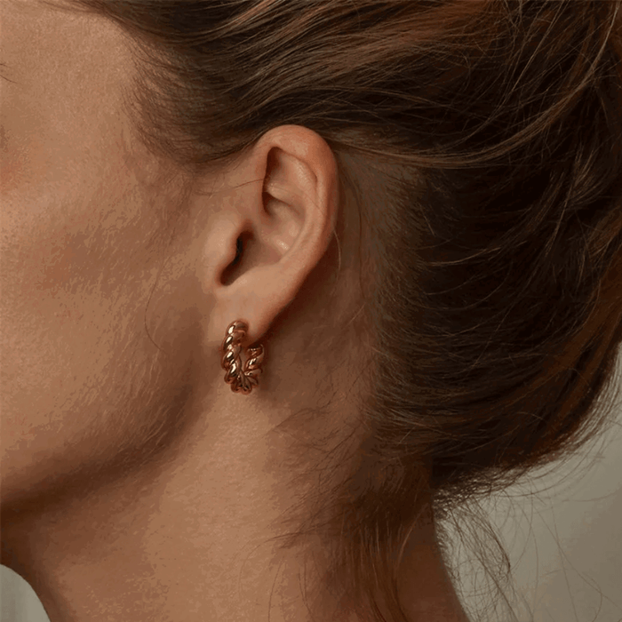 Gold hoop earring with twisted rope texture and small stud clasp