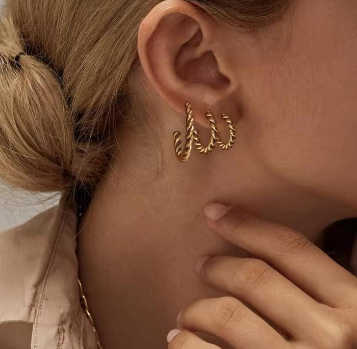Gold twisted rope hoop earrings, multiple sizes on ear