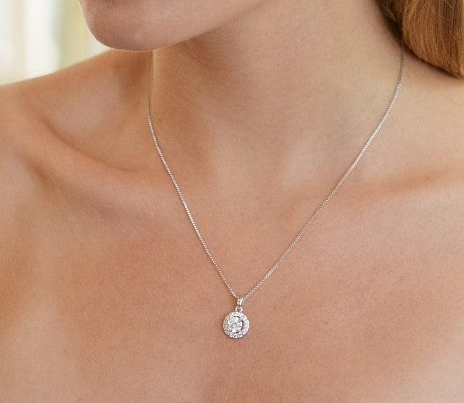 Round halo crystal pendant necklace worn on a silver chain with small round clasp