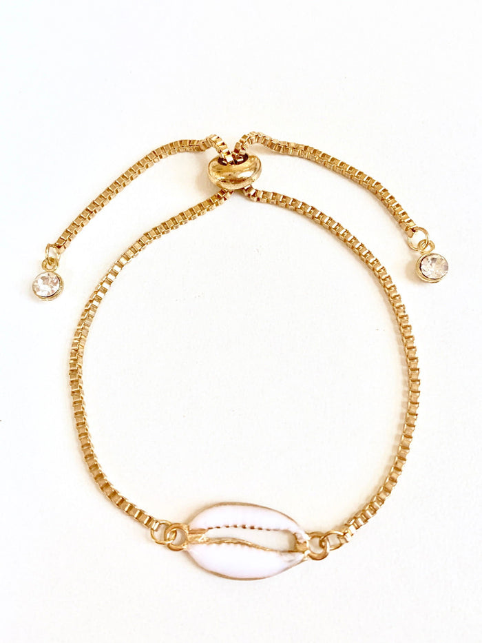 Gold seashell charm bracelet with round crystal bead details and adjustable spring clasp.