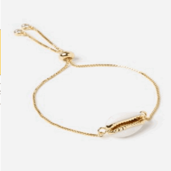 Gold seashell bracelet, angled view; oval shell charm with beaded chain and clasp rings
