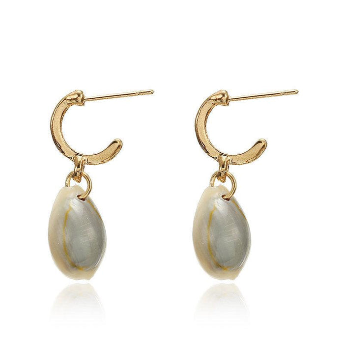 Gold hoop earrings with oval puka shell drops and small cowrie shell detail