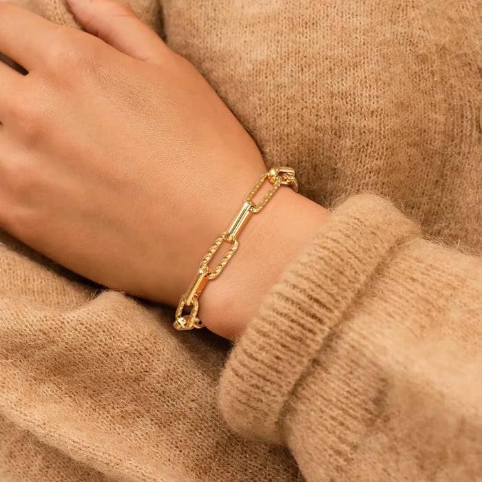 Gold paperclip chain bracelet stacked on wrist with adjustable clasp
