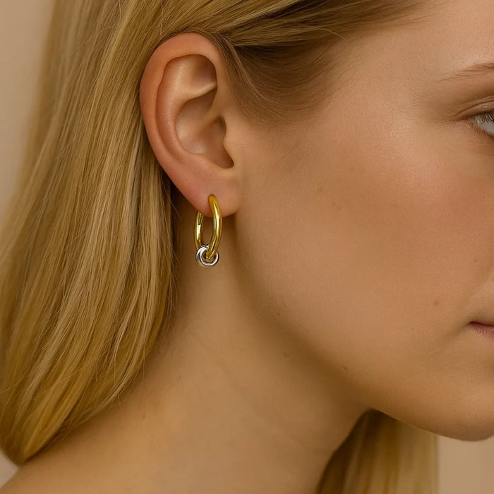 Two-tone hoop earrings on ear, gold hoops with silver accent bar