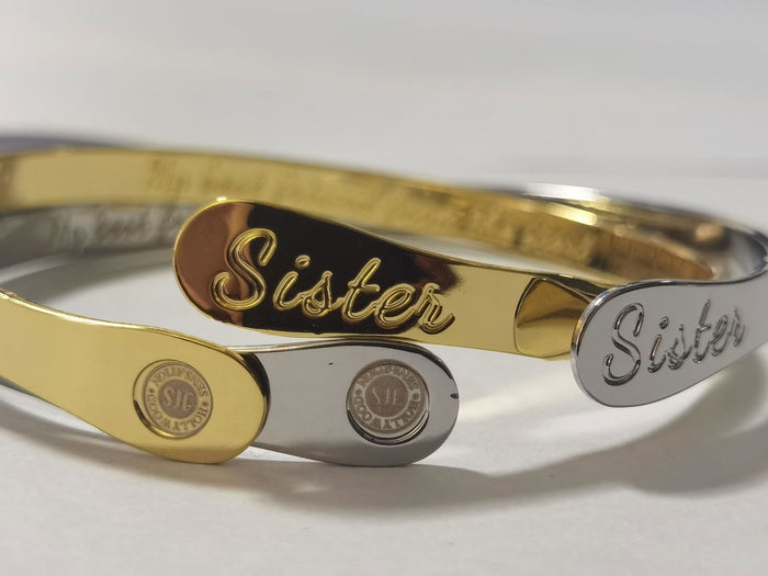Stacked sister bracelets in gold and silver with engraved nameplates