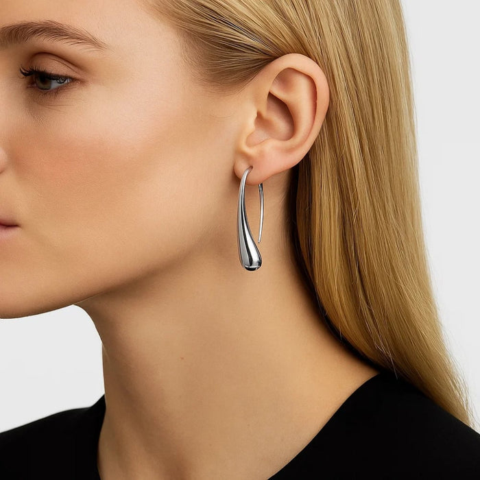 Silver teardrop hook earrings on model, smooth curved oval drop