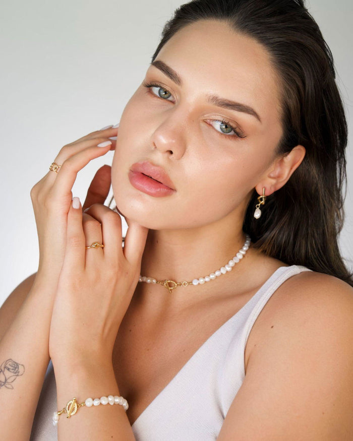 Freshwater pearl bracelet on wrist with gold baroque charm and clasp