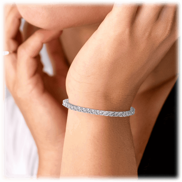 Silver cubic zirconia tennis bracelet cuff on wrist, sparkling detail