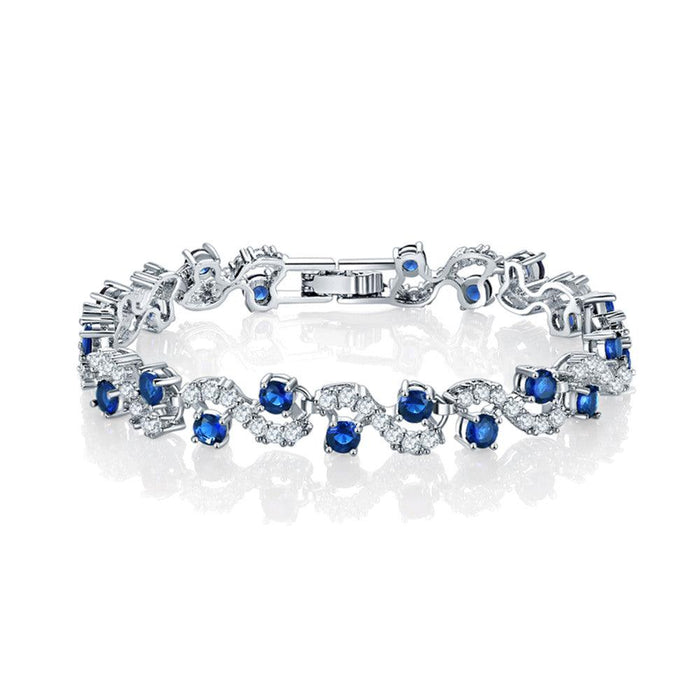 Sapphire blue round-stone tennis bracelet with clear accents, silver-tone links