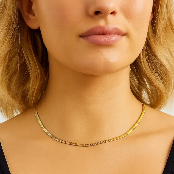 Gold snake chain necklace on model, thin coil-like links