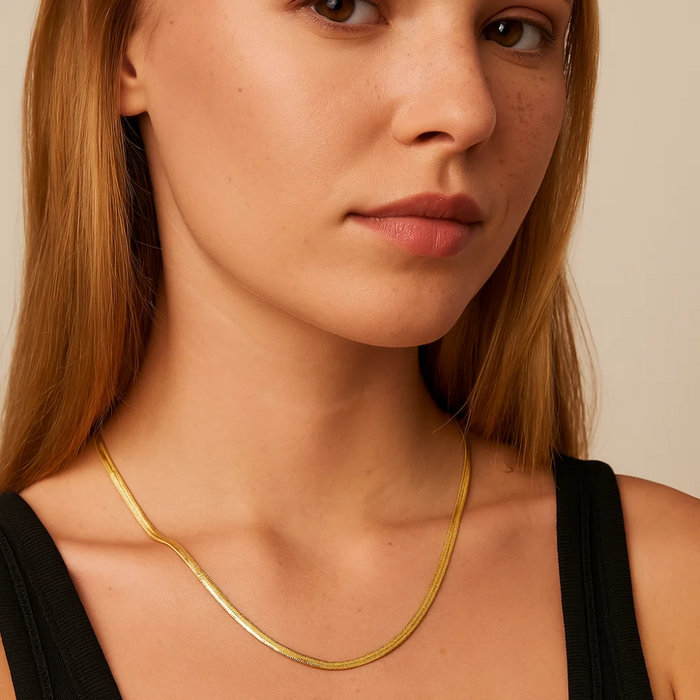 Gold snake chain necklace on neckline, slim links and short collar fit