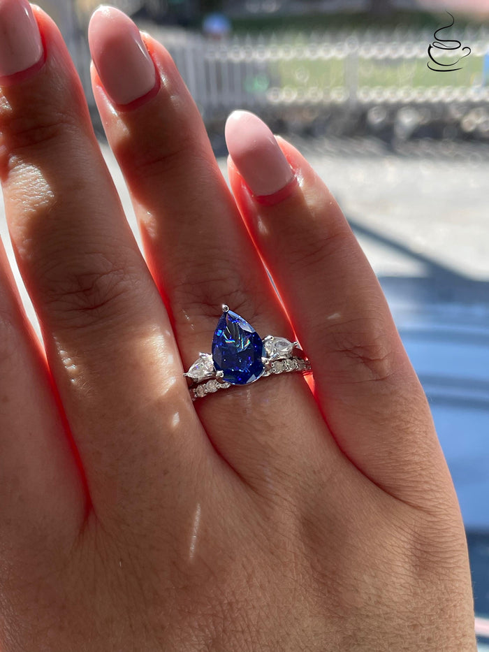 There stone engagement ring with pear cut crushed ice blue sapphire and moissanite half eternity band, September birthstone ring