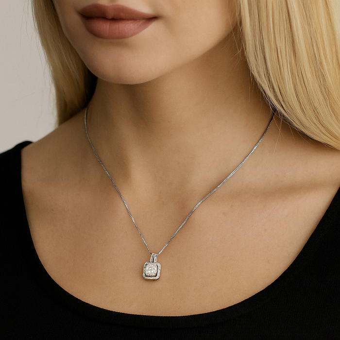 Cushion-cut cubic zirconia halo pendant on a delicate silver-tone chain necklace.