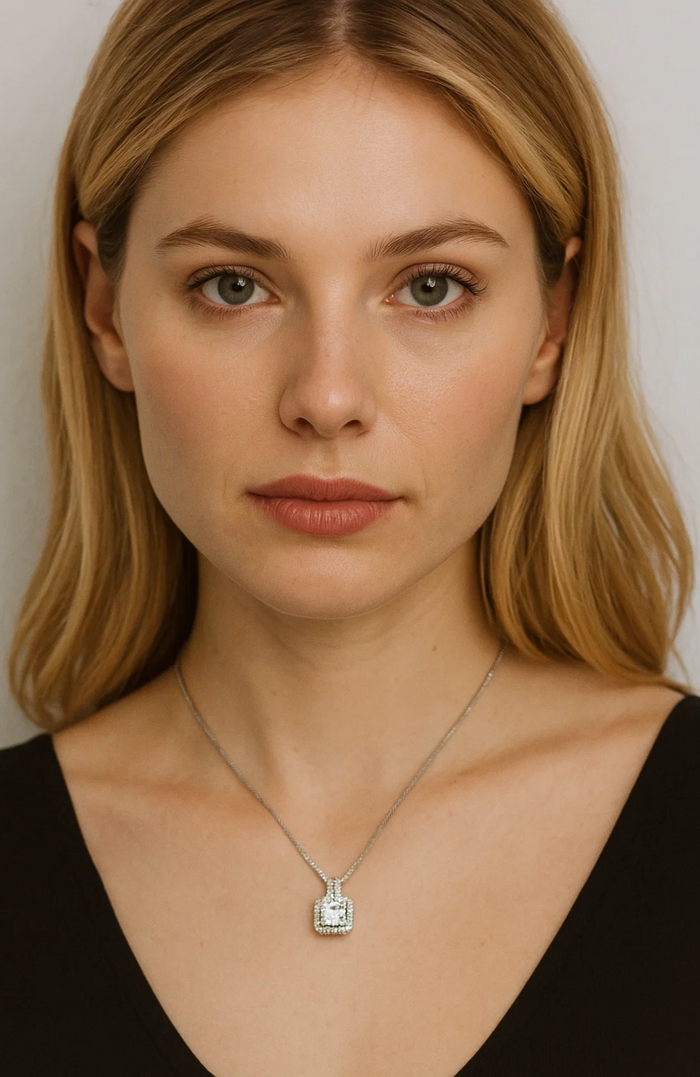 Cubic zirconia cushion pendant necklace with halo border and thin silver-tone chain.