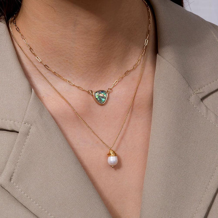 Two-layer necklace worn on neck: abalone heart pendant and pearl drop