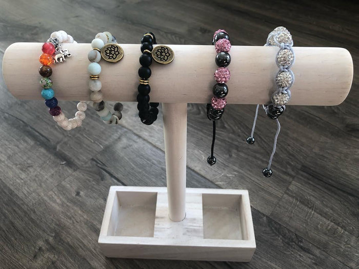 Set of beaded yoga bracelets on a display stand, multiple colors and charm pendants